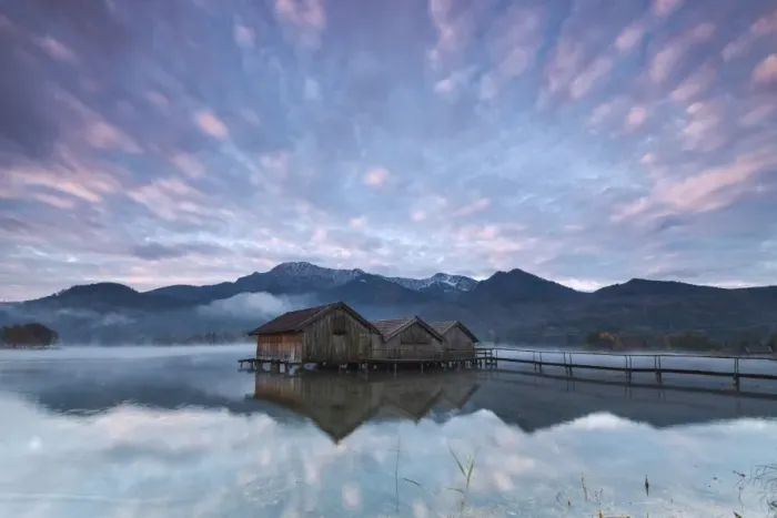 Framed Print : Pink clouds at sunset and wooden huts are reflected in the clear water of Kochelsee Framed Print : Pink clouds at sunset and wooden huts are reflected in the clear water of Kochelsee