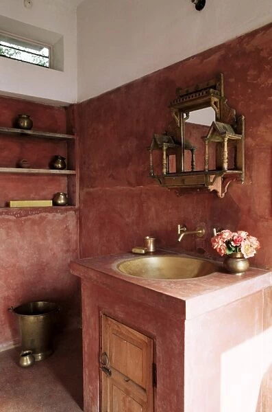 Pink finished plaster walls and hand beaten brass bathroom sink