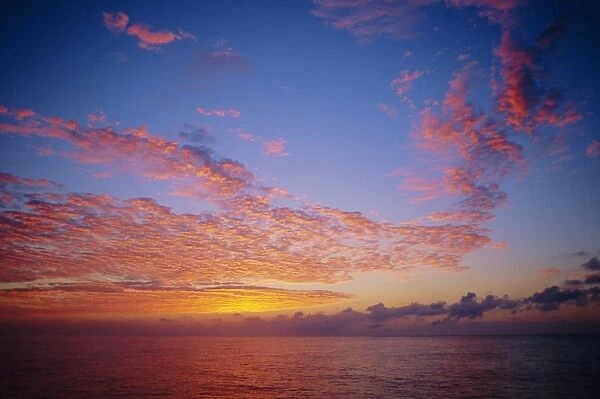 Pink and orange clouds at sunrise over the English Channel, England, UK
