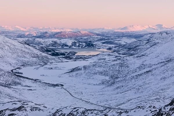 Pink sky at sunset on the snowy landscape and frozen sea surrounding Fjordbotn, Lysnes