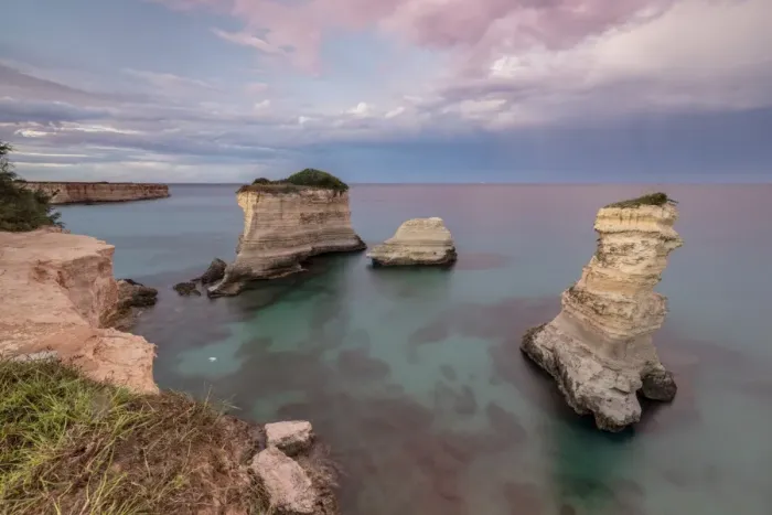 Framed Print : Pink sunset frames the cliffs known as Faraglioni di Sant Andrea and the turquoise sea Framed Print : Pink sunset frames the cliffs known as Faraglioni di Sant Andrea and the turquoise sea