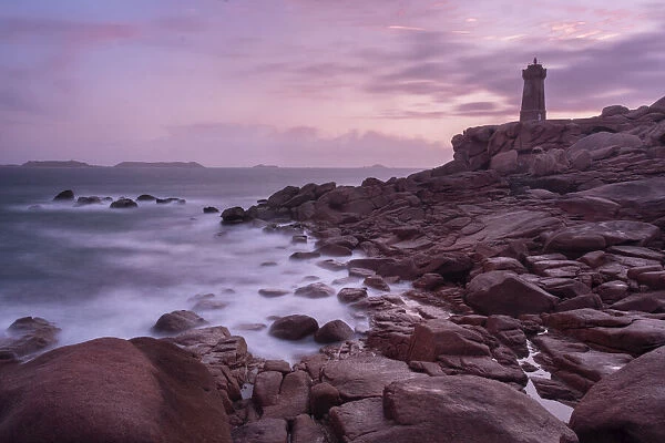 Pink sunset long exposure at Ploumanach lighthouse with the pink granite coast, Cotes d Armor, Brittany, France, Europe
