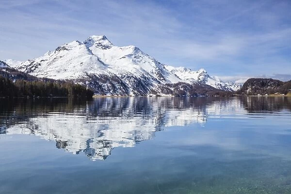 Piz da la Margna is reflected in the clear water of Lake Sils, Maloja Pass, Engadine