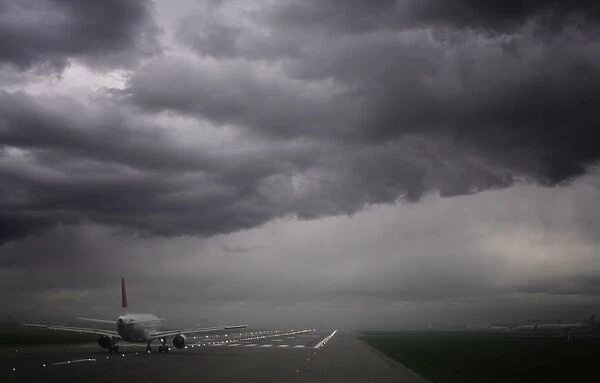 Plane ready for take off and stormy skies, Heathrow Airport, London, England