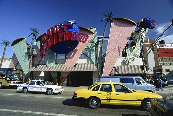 Planet Hollywood restaurant sign and passing taxis