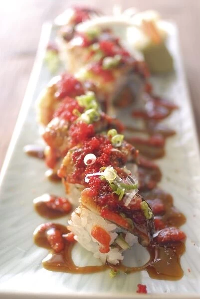 Plate of sushi rolls with hot sauce