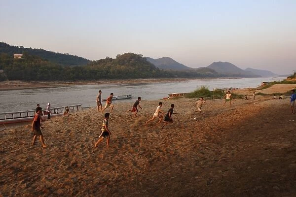 Playing football on the banks of the Mekong river