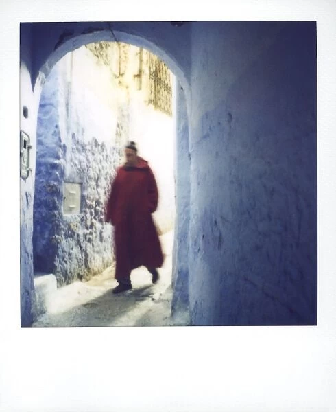 Polaroid of man wearing red djellaba walking through