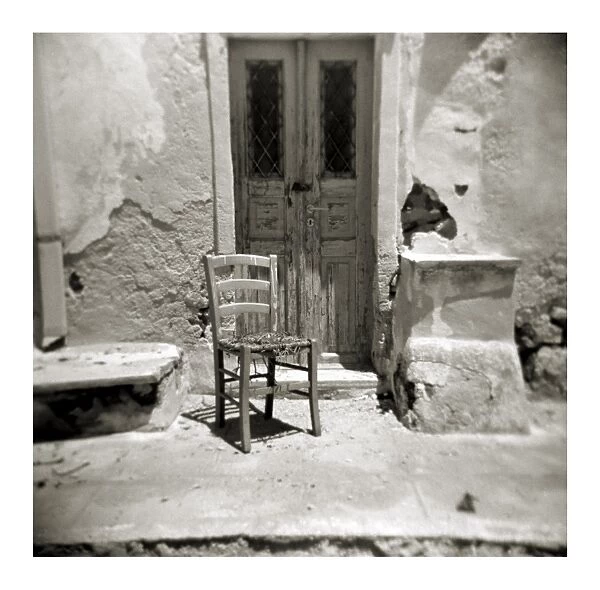 Polaroid of old chair outside building damaged by earthquake