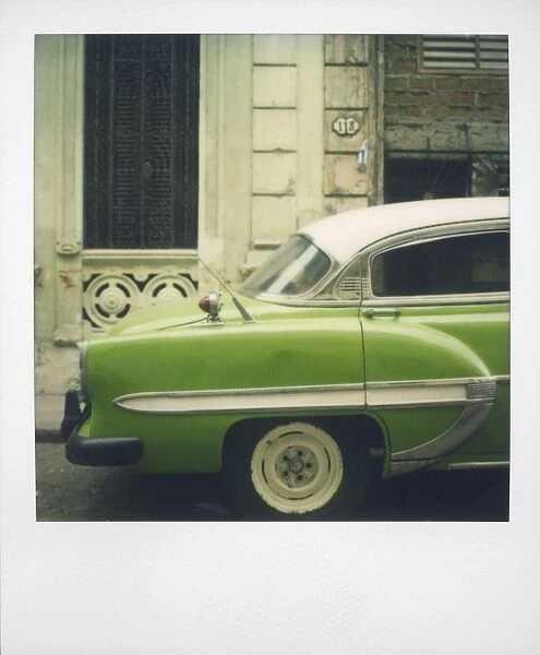 Polaroid of profile of green classic American car parked on street, Vinales