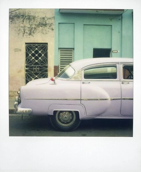 Polaroid of profile of purple classic American car against green and yellow walls