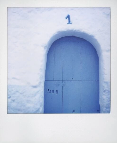 Polaroid of traditional painted blue door against bluewashed wall
