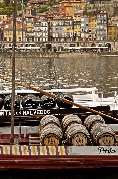 Port wine barrels on a boat on River Douro with Vila Nova de Gaia in the background