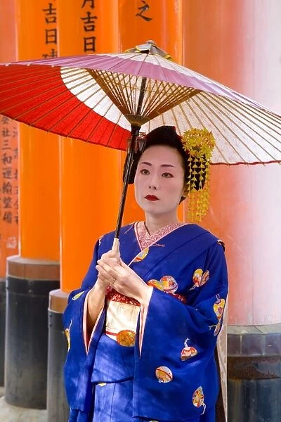 Portrait of a geisha holding an ornate red umbrella