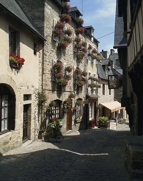 Pots and windowboxes of geraniums on houses on the Rue de Jerzual in Dinan