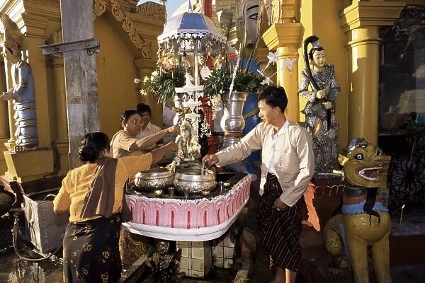 Pouring water on the Buddha, Shwedagon Pagoda, Yangon (Rangoon), Myanmar (Burma), Asia