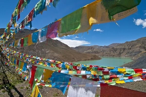 Prayer flags above an artifical lake near the Karo-La Pass, Tibet, China, Asia