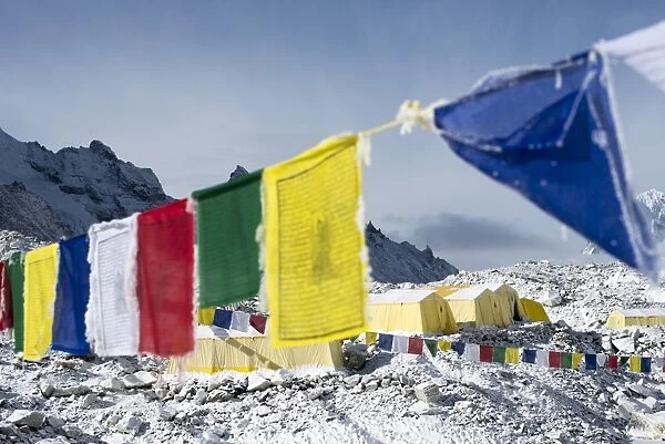 Prayer flags and the Everest base camp at the end of the Khumbu glacier that lies at 5350m