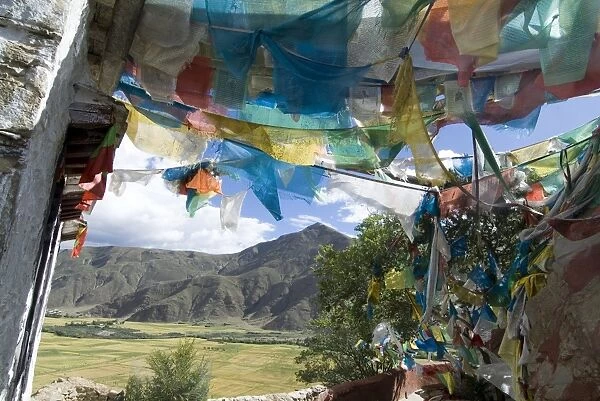 Prayer flags and view over cultivated fields, Yumbulagung Castle, Tibet, China, Asia