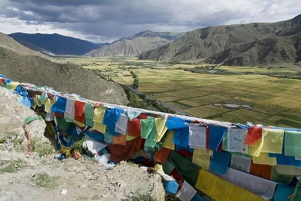 Prayer flags and view over cultivated fields, Yumbulagung Castle, Tibet, China, Asia