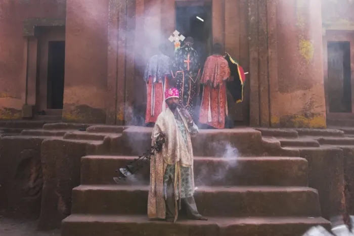 Framed Print : Priest swings an incense burner at the rock-hewn monolithic church of Bet Giyorgis (St