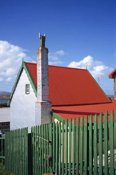 A private house with red corrugated roof and green fence in Stanley, capital of the Falkland Islands