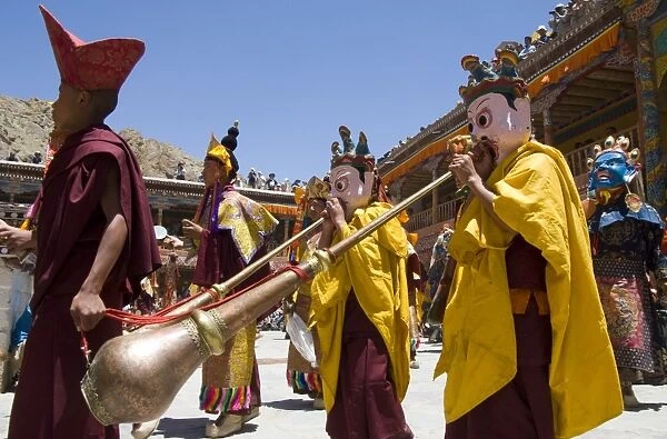 Procession in monastery courtyard with monk musicians