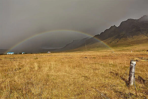 A rainbow arcs across countryside near the town of Stykkisholmur, Snaefellsnes peninsula, west coast of Iceland, Polar Regions