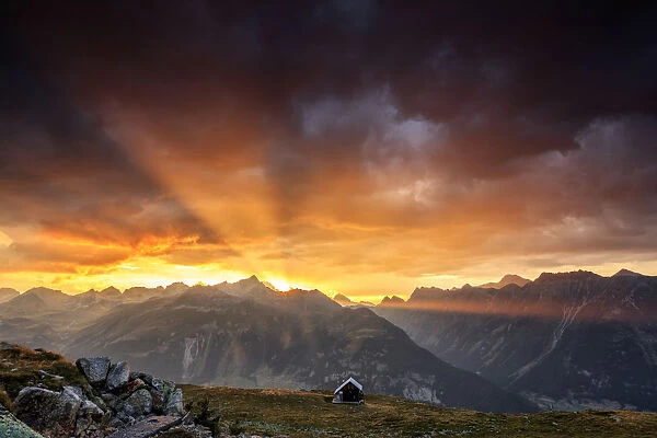 Rays of sun of fiery sky at sunset above the peaks, Muottas Muragl, St