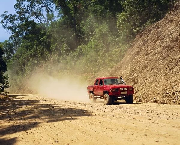A red 4x4 pick-up on the dusty Bloomfield Track, Cape Tribulation National Park
