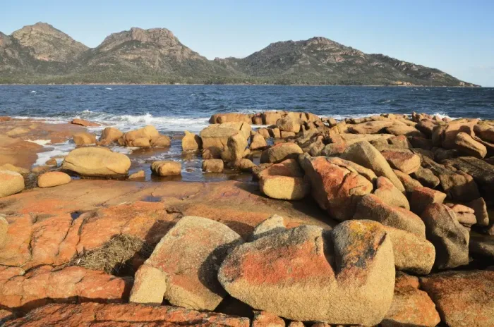 Framed Print : Red lichen on rocks, The Hazards and Coles Bay, Freycinet National Park Framed Print : Red lichen on rocks, The Hazards and Coles Bay, Freycinet National Park
