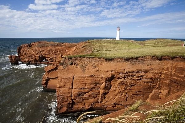 Red sandstone cliff and lighthouse on Cap-aux-Meules Island on the Iles de la Madeleine