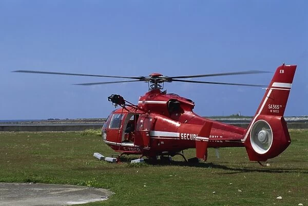 Red security helicopter on the ground carrying a wounded person, on Sein island