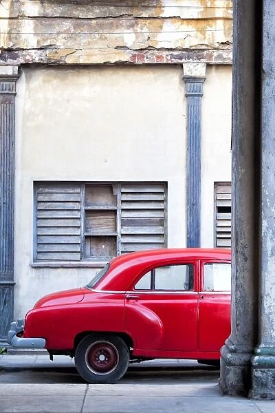 Red vintage American car parked on a street in Havana Centro, Havana, Cuba, West Indies, Central America