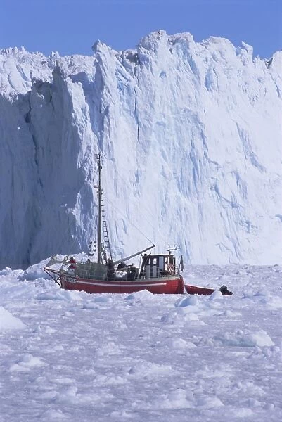 Red wooden boat crossing the ice in front of the Eqi Glacier
