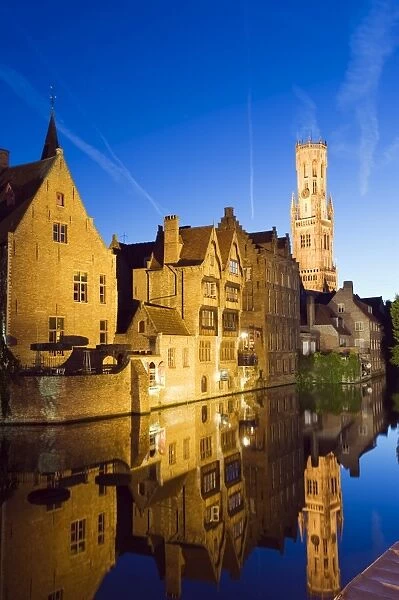 Reflection in canal of Belfort (belfry tower) illuminated at night, Old Town