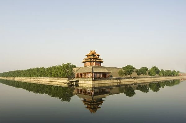 A reflection of a palace wall tower surrounded by the moat of The Forbidden City Palace Museum