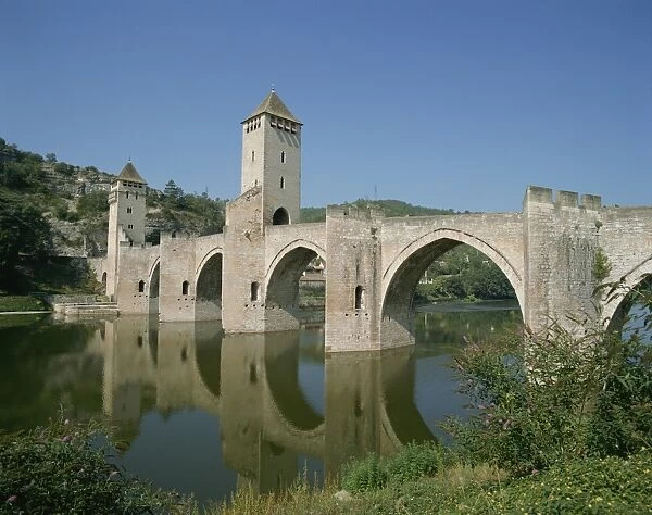 Reflections of the bridge and towers of the Pont Valentre across the River Lot at Cahors