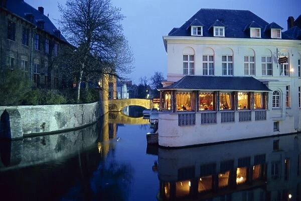 Reflections in the canals of restaurant and bridge, illuminated in the evening