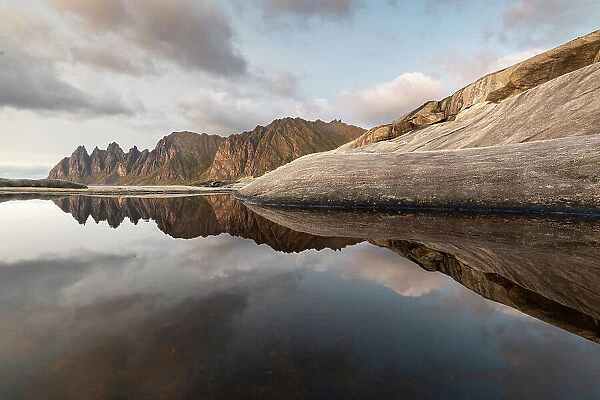Reflections of clouds, rocks and Devil's Teeth Mountain in evening sunlight, Tungeneset, Senja, Norway, Scandinavia, Europe