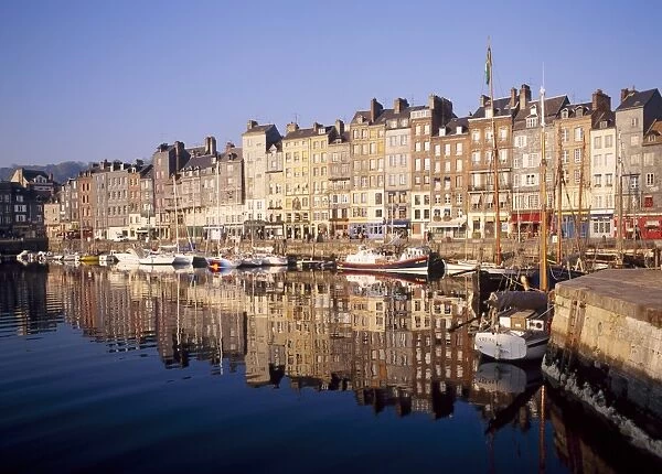 Reflections of houses and boats in the old harbour at St Catherines Quay in Honfleur