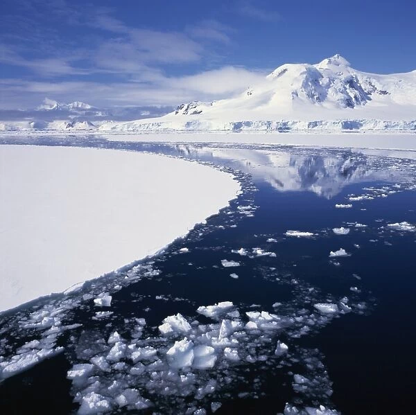 Reflections in icy sea of snow covered mountain, on the west coast of the Antarctic Peninsula