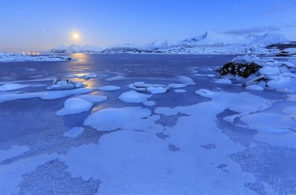 Reflections of full moon in the frozen sea, Lyngedal, Lofoten Islands, Arctic, Norway