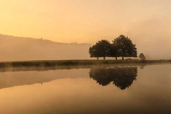 Reflections in River Derwent, dawn and autumn mist, Chatsworth Park, Peak District National Park
