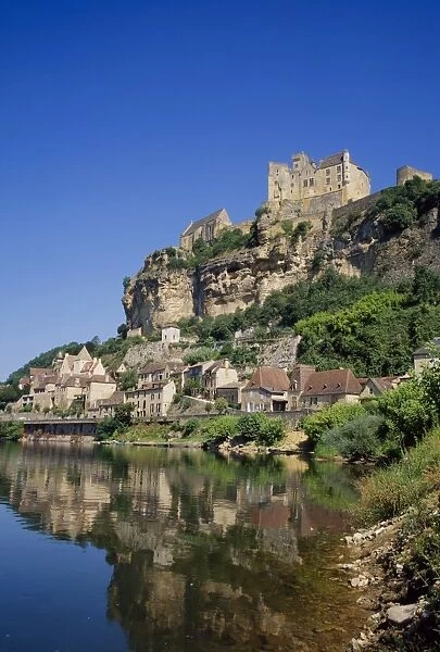 Reflections in the River Dordogne of the town and castle at Beynac, in Aquitaine