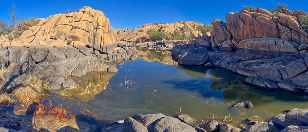 Reflective lagoon along East Bay Trail of Willow Lake, gray line on rock is where the water level used to be, Prescott, Arizona, United States of America, North America