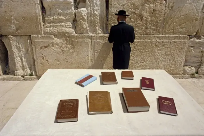 Framed Print : Religious books on table and Jewish man facing the Western Wall Framed Print : Religious books on table and Jewish man facing the Western Wall