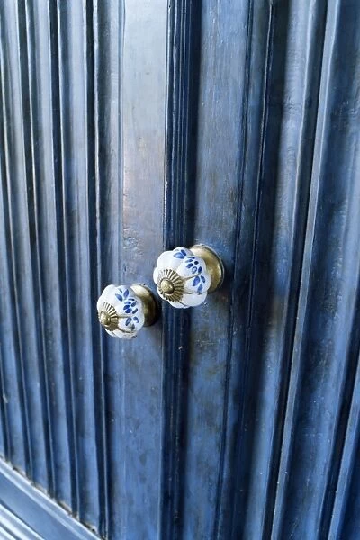 Detail of reproduction hand painted china cupboard door knobs in a home