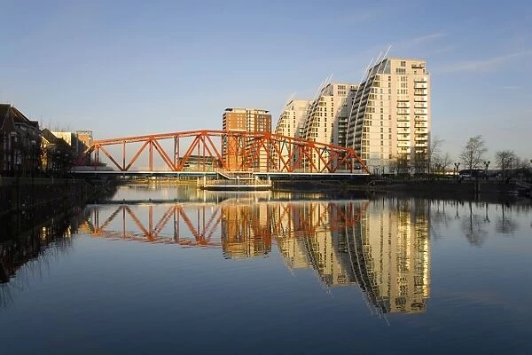 Residential tower blocks and colourful bridge reflected in water, Salford Quays, Salford, Greater Manchester, England, United Kingdom, Europe