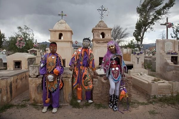 Revellers in costumes and masks at a cemetery in Humahuaca during carnival in Jujuy